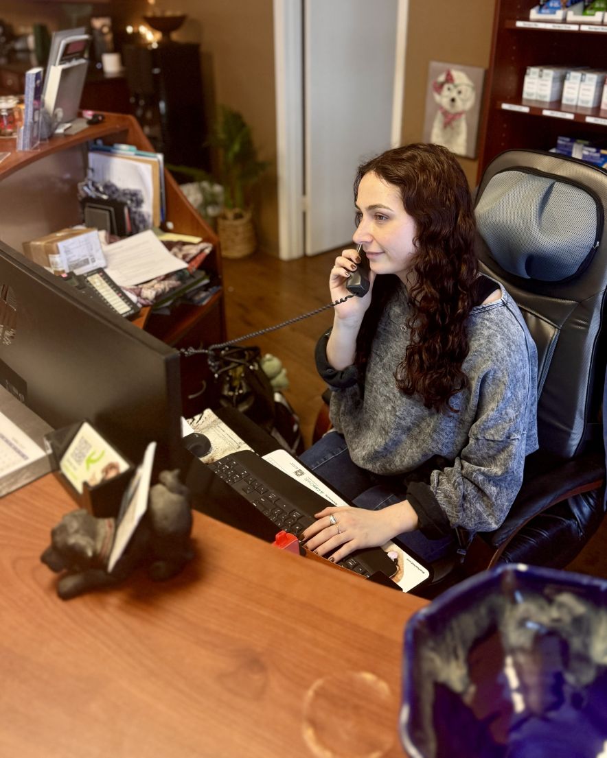 Baylee working at the reception desk at Hearthstone Animal Clinic
